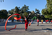 Morgensport im Jingshan Park, Tänzerin trainiert das Schleifentanz, rhythmische Gymnastik mit Schleifenband,  Körperertüchtigung, Peking, China