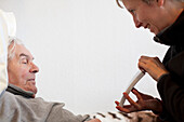 Woman visiting grandfather in retirement home, Leipzig, Saxony, Germany