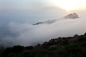 Blick auf Nebelmeer und Sonnenuntergang, Steilküste, Wanderung zur Landspitze Capo Rosso zwischen Porto und Cargese, Blick zum Turm von Turghio auf dem Capo Rosso, Porto, Korsika, Frankreich