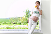 Pregnant woman drinking a glass of juice, Rerik, Mecklenburg-Western Pomerania, Germany