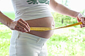Pregnant woman measuring belly, Rerik, Mecklenburg-Western Pomerania, Germany
