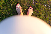 Schwangere Frau blickt auf ihre Füße, Leipzig, Sachsen, Deutschland