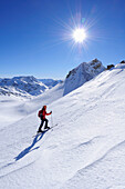 Woman backcountry skiing ascending towards Piz Surgonda, Julierpass, Albula range, Upper Engadin, Engadin, Grisons, Switzerland, Europe