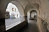 Arcade covered sidewalk pavement on Laubengasse, a street in Mediaeval walled town of Glurns in the Val Venosta, Italian Alps