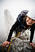 Female mountaineer at Kopftoerlgrat, Kapuzenturm in background, Ellmauer Halt, Kaiser Mountain Range, Tyrol, Austria