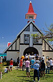 People in front of the Notre Dame Auxiliatrice chapel under blue sky, Cap Malheureux, Mauritius, Africa