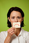 Mid adult woman holding postit note