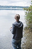 Mädchen steht am Ufer vom Starnberger See, Bayern, Deutschland