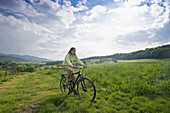 Radfahrerin auf einer Wiese, Hexental, Schwarzwald, Baden-Württemberg, Deutschland, Europa