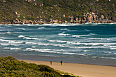 Two hikers walking along Norman Beach, Wilsons Promontory National Park, Victoria, Australia