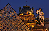 Glaspyramide und Reiterdenkmal im Innenhof des Louvre am Abend, Paris, Frankreich