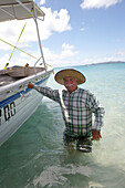 Geoff Mercer, Hotelier und Bewohner von Great Keppel Island, im Wasser an seinem Boot, Great Keppel island, Great Barrier Reef Marine Park, UNESCO Weltnaturerbe, Queensland, Australien