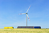 Windkraftanlage steht über Sonnenkollektor mit Getreidefeld im Vordergrund, Ulm, Baden-Württemberg, Deutschland, Europa