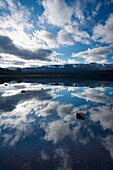 Scotland, Scottish Highlands, Cairngorms National Park Dramatic clouds and Cairngorm mountains reflected upon the still face of Loch Morlich