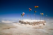 Bolivia, Southern Altiplano, Salar de Uyuni Flags situated upon a mound of salt in the Salar de Uyuni salt flat