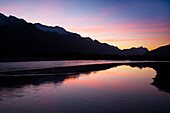 New Zealand, Otago, Glenorchy Sunset reflected in the moving waters near the mouth of Lake Wakatipu