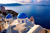 Oia, Ia Santorini - Blue domed Byzantine Orthodax churches, Greek Cyclades islands.