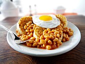 Baked beans on crumpets with fried egg on top