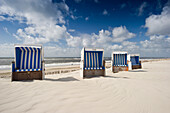Roofed wicker beach chairs at sandy beach, Westerland, Sylt, Schleswig-Holstein, Germany