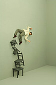 Man falling off tall stack of chairs