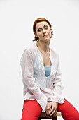 Young woman sitting on stool, portrait