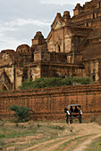Bagan, Myanmar, horse-drawn carriage riding in front of Dhammayangyi Temple