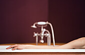 Woman's arm on edge of bathtub