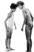 Two girls in bathing suits touching foreheads