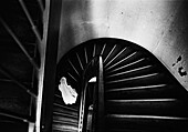 Woman with vail coming up spiral staircase, b&w
