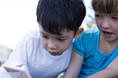 Children playing with handheld video game, close-up