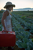 Woman with Suitcase in Cabbage Field