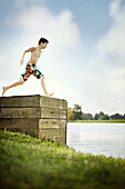 Boy Jumping Off Dock Into Lake