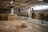 Frau betrachtet römische Mosaiken am Boden der Krypta der Basilica Patriarcale di Aquileia Kathedrale, Aquileia, Provinz Udine, Friaul-Julisch-Venetien, Oberitalien, Italien