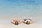 2 boys lying on the beach