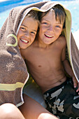 2 smiling children wrapped in towel
