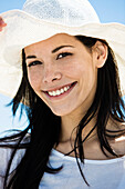 Portrait of young smiling woman, white hat