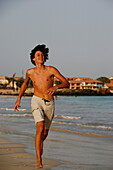 Cape Verde Peninsula, Sal, Santa Maria beach, teenage boy running on the beach