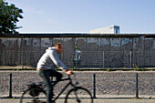 Germany, Berlin, Zimmerstrasse,  biker near th Wall, west side