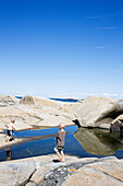 Two Young Boys Playing in Tidal Pool Along Rocky West Coast, Sweden