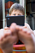 Boy playing with handheld game console, Lankau, Schleswig-Holstein, Germany