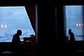 Mann sieht aus dem Fenster einer Herberge, Chandolin, Anniviers, Wallis, Schweiz