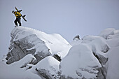 Snowboarder standing on a snow-covered rock, Chandolin, Anniviers, Valais, Switzerland