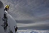Snowboarder steht auf einem Berggipfel, Chandolin, Anniviers, Wallis, Schweiz