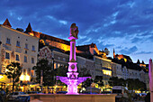 Blick auf beleuchteten Brunnen am Stadtplatz mit Burg, Burghausen, Bayern, Deutschland, Europa