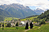 Two nuns in front of the abbey of Muestair, valley Muenstertal, Grisons, Switzerland, Europe
