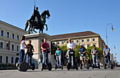 Menschen auf Segways während einer Stadtführung am Ludwig I-Denkmal, Ludwigstraße, München, Bayern, Deutschland, Europa
