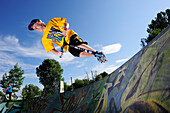 Junger Mann im Sprung mit einem Tretroller, Skatepark, München, Oberbayern, Bayern, Deutschland