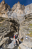 Mountain hiker passing stream Schafbach, Lauterbrunnen Valley, Canton of Bern, Switzerland