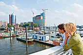 Paar blickt auf Baustelle der Elbphilharmonie, HafenCity, Hamburg, Deutschland