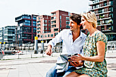 Couple holding a city map at Magellan-Terraces, HafenCity, Hamburg, Germany